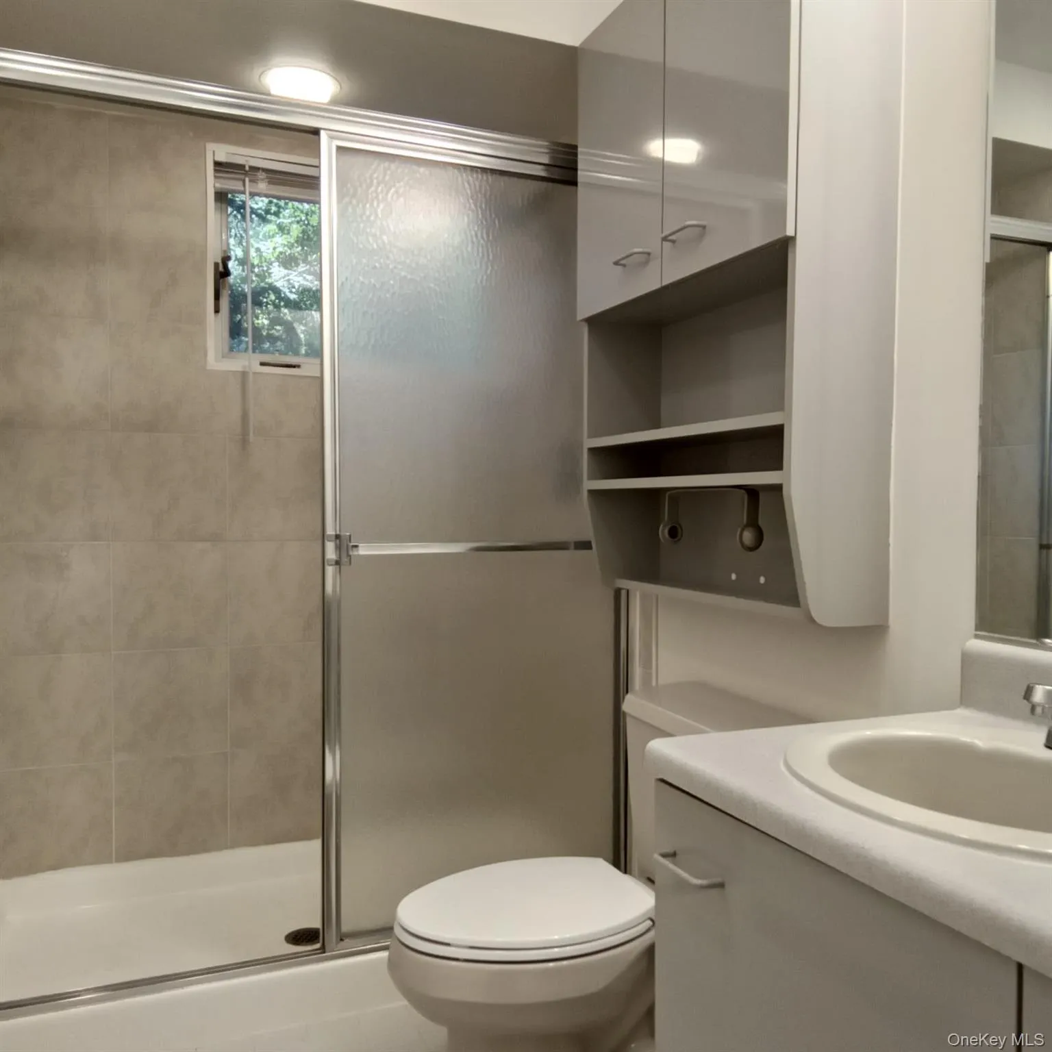 Bathroom featuring a shower stall and vanity Bathroom featuring a shower stall and vanity