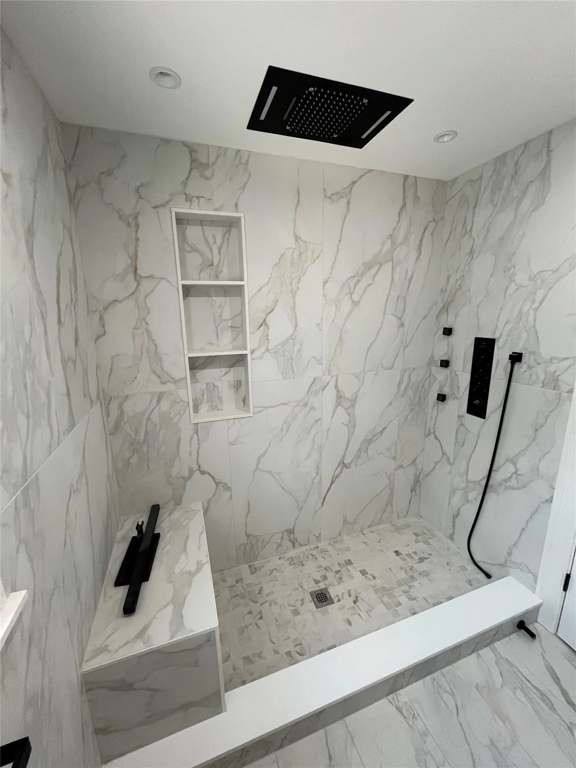 Bathroom with a marble finish shower, marble finish floors, and recessed lighting Bathroom with a marble finish shower, marble finish floors, and recessed lighting