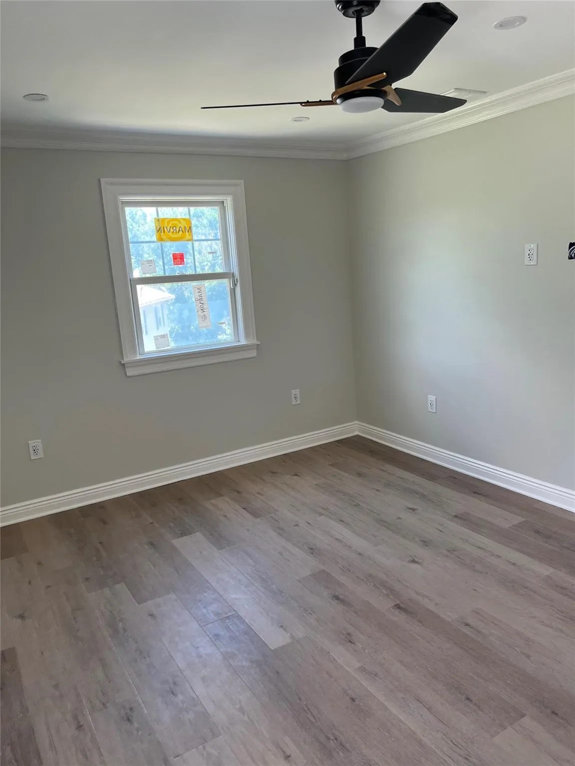 Spare room with a ceiling fan, crown molding, and wood finished floors Spare room with a ceiling fan, crown molding, and wood finished floors