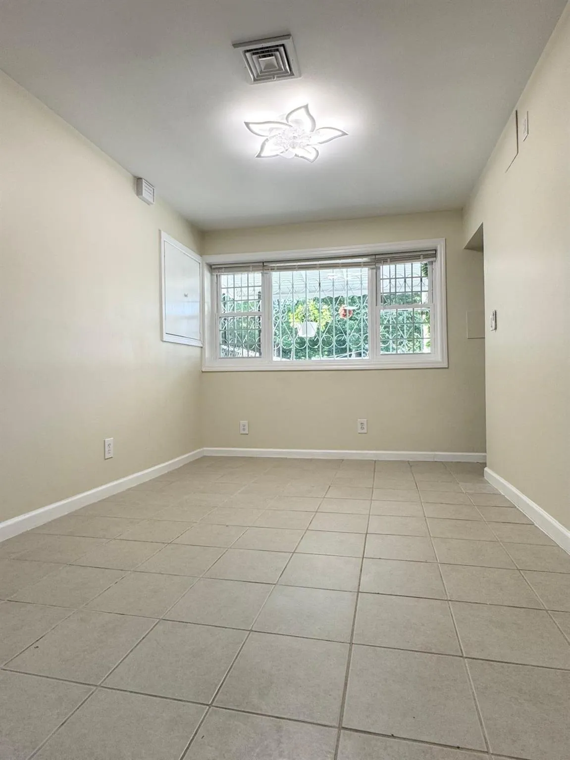 Empty room featuring healthy amount of natural light and light tile patterned flooring Empty room featuring healthy amount of natural light and light tile patterned flooring