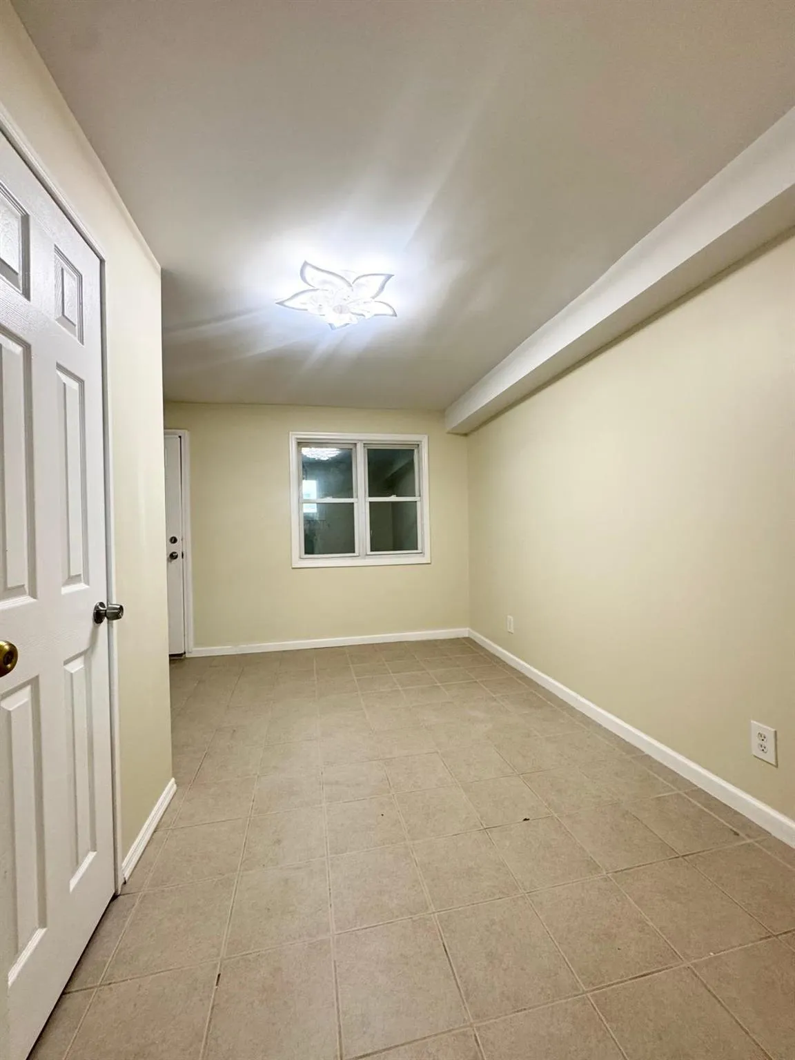 Spare room with light tile patterned flooring and baseboards Spare room with light tile patterned flooring and baseboards