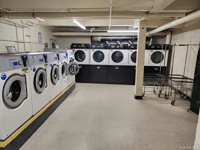 Community laundry with washing machine and clothes dryer and tile patterned floors Community laundry with washing machine and clothes dryer and tile patterned floors