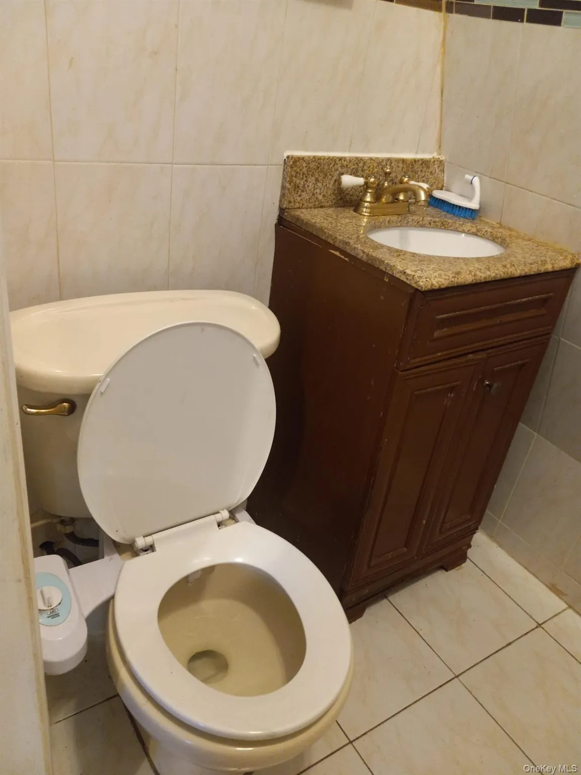 Half bathroom with tile walls, vanity, and tile patterned floors Half bathroom with tile walls, vanity, and tile patterned floors