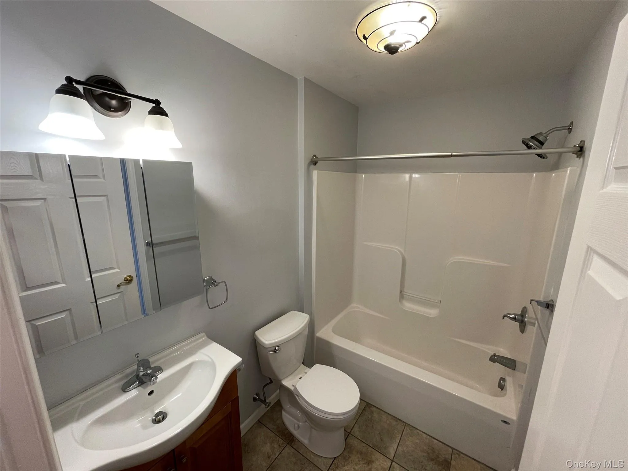 Full bathroom featuring vanity, washtub / shower combination, and tile patterned flooring Full bathroom featuring vanity, washtub / shower combination, and tile patterned flooring