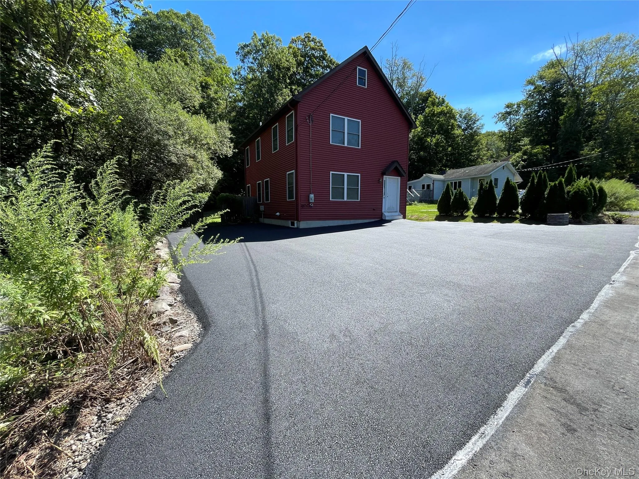 View of home's exterior featuring driveway and view of wooded area View of home's exterior featuring driveway and view of wooded area