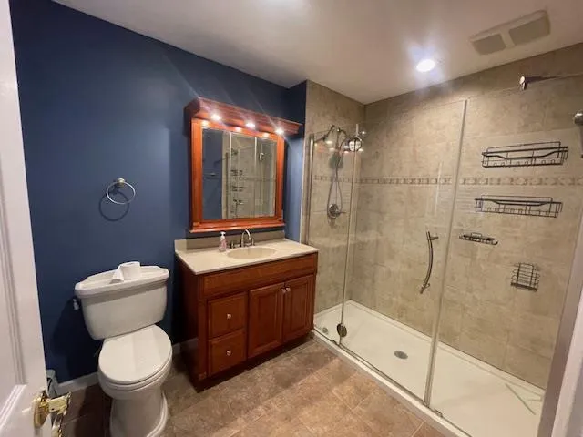 Bathroom featuring a shower stall and vanity Bathroom featuring a shower stall and vanity