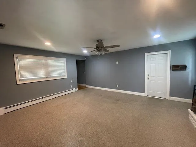 Carpeted spare room with a baseboard radiator, recessed lighting, and a ceiling fan Carpeted spare room with a baseboard radiator, recessed lighting, and a ceiling fan