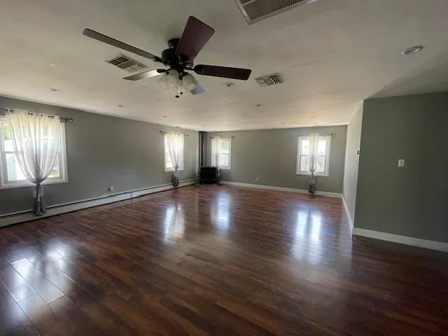 Living Room featuring a ceiling fan and wood finished floors Living Room featuring a ceiling fan and wood finished floors