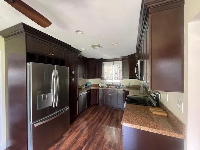 Kitchen with stainless steel appliances, dark wood-style flooring, dark brown cabinetry, and recessed lighting Kitchen with stainless steel appliances, dark wood-style flooring, dark brown cabinetry, and recessed lighting