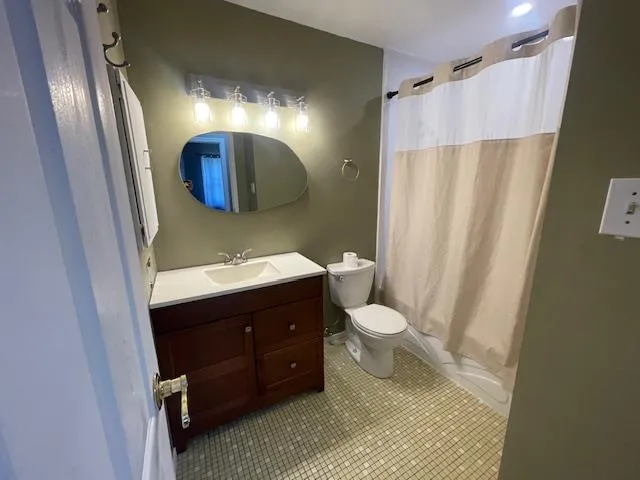 Bathroom with vanity, shower / bath combo, and tile patterned flooring Bathroom with vanity, shower / bath combo, and tile patterned flooring