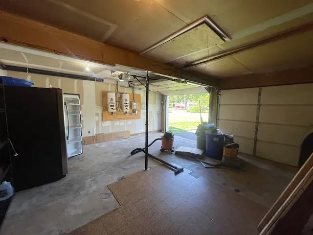 Garage with freestanding refrigerator and a garage door opener Garage with freestanding refrigerator and a garage door opener