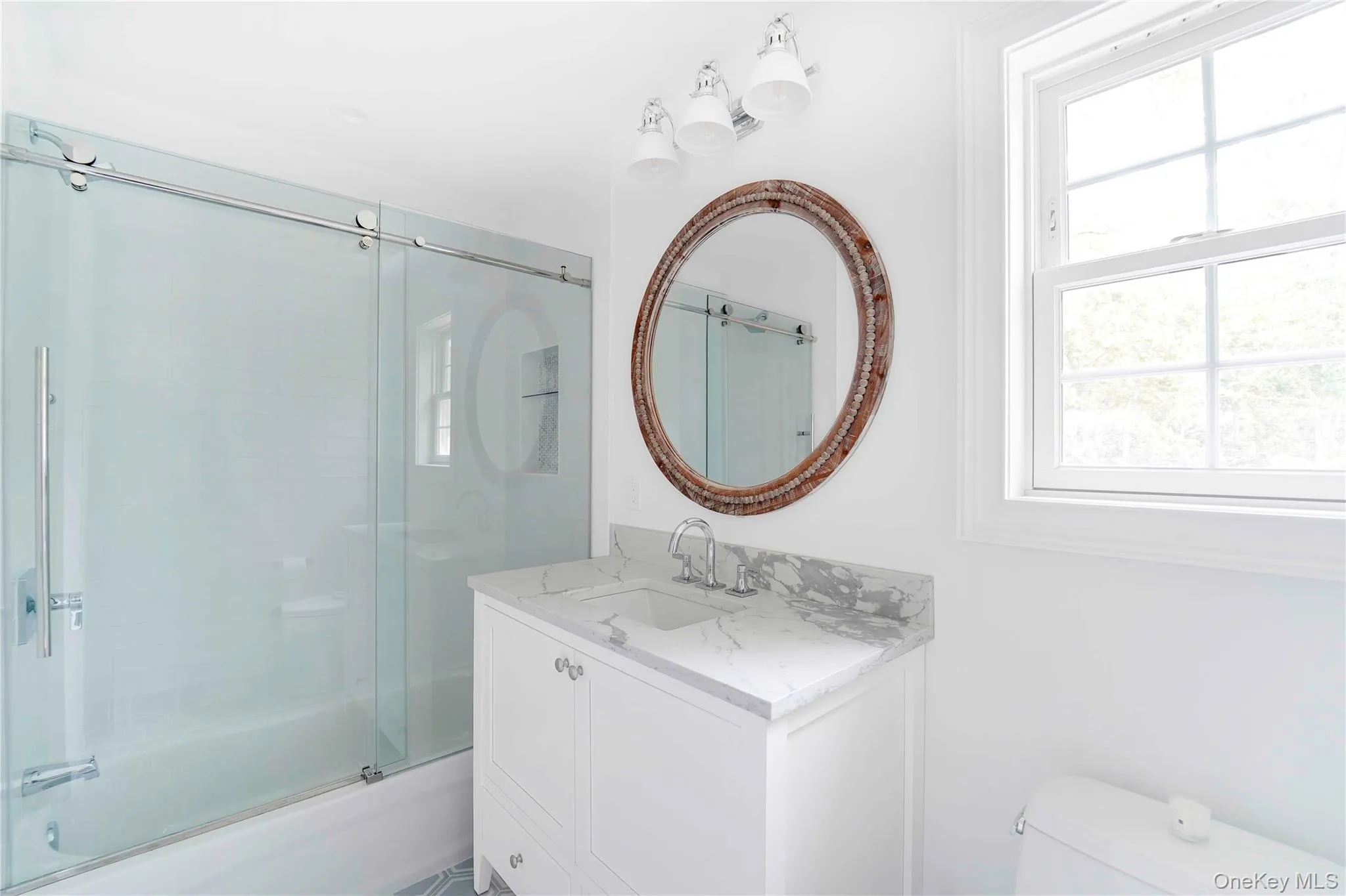 Bathroom with vanity and combined bath / shower with glass door Bathroom with vanity and combined bath / shower with glass door