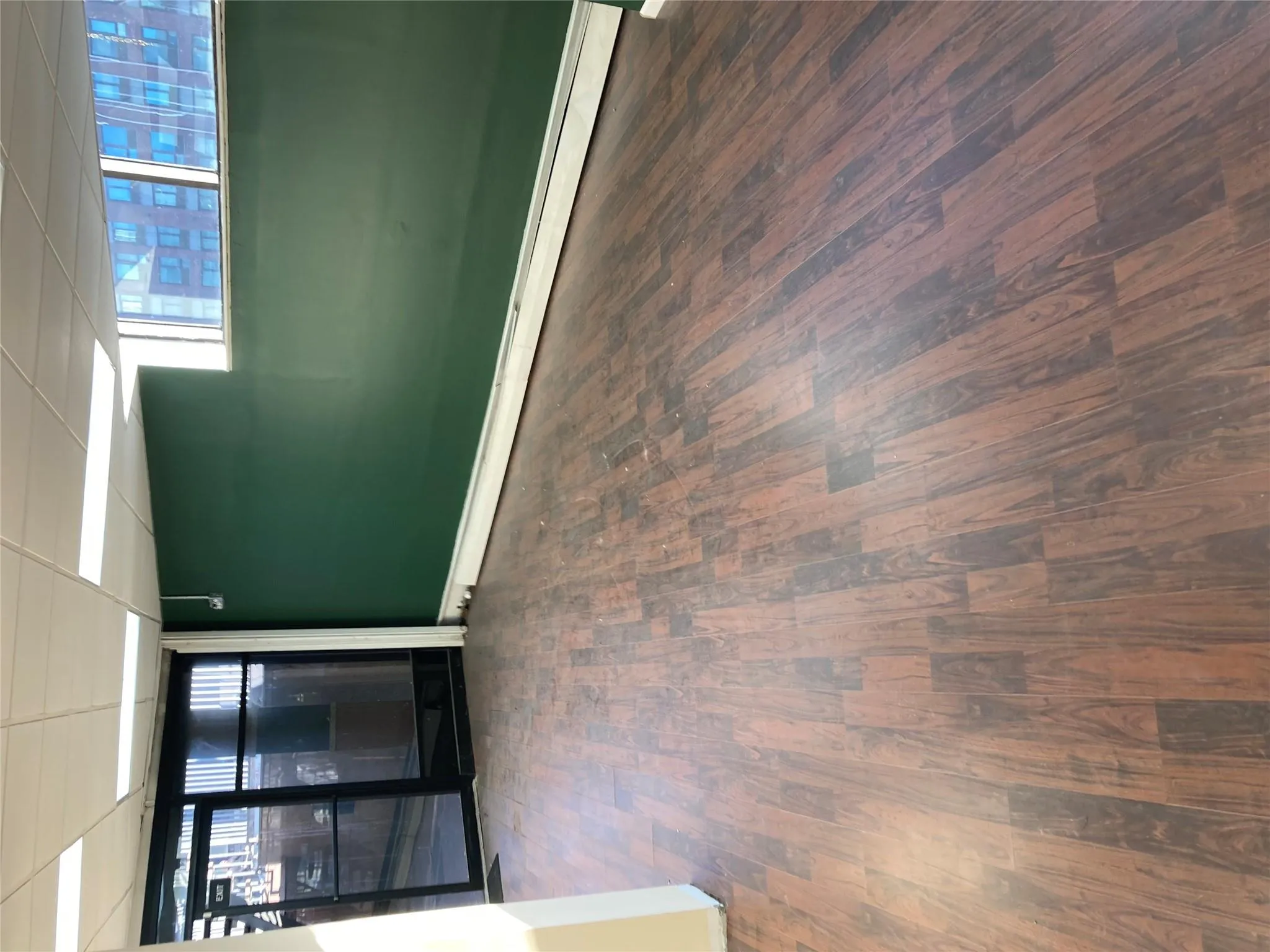 Below grade area featuring wood finished floors, a paneled ceiling, and baseboard heating Below grade area featuring wood finished floors, a paneled ceiling, and baseboard heating
