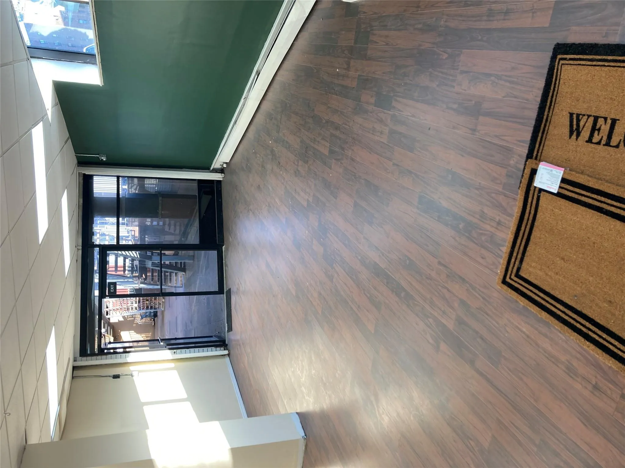 Unfurnished room with a baseboard radiator, wood finished floors, and a paneled ceiling Unfurnished room with a baseboard radiator, wood finished floors, and a paneled ceiling
