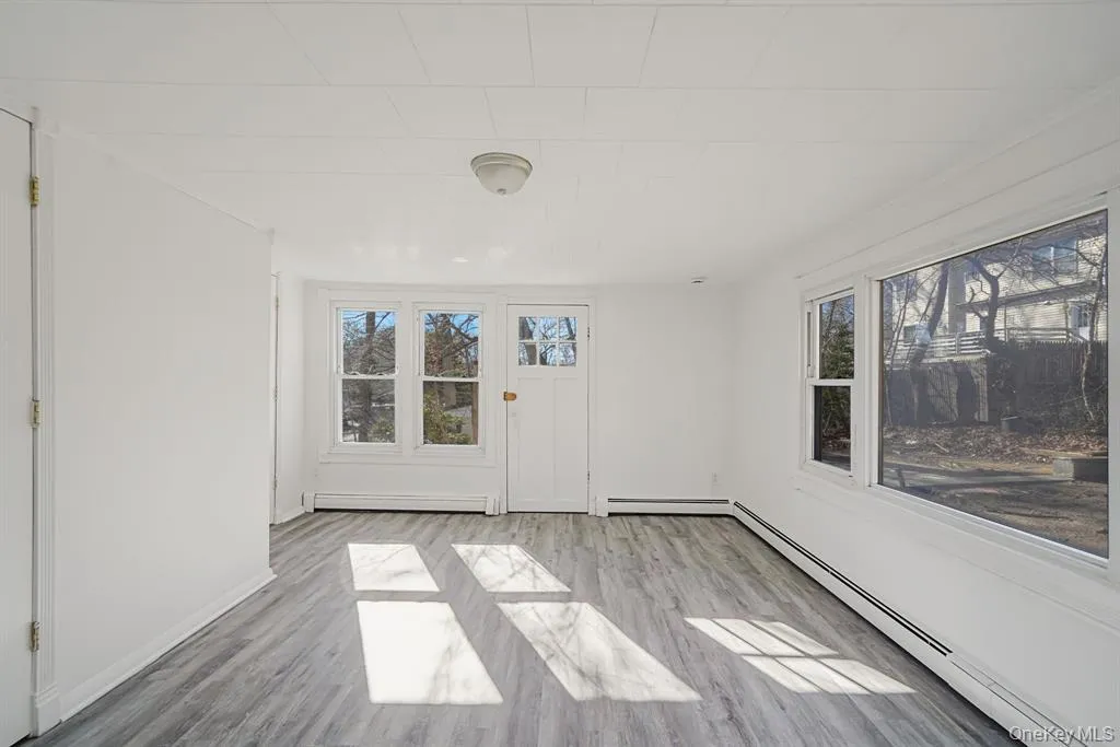 Spare room with a baseboard heating unit and wood finished floors Spare room with a baseboard heating unit and wood finished floors