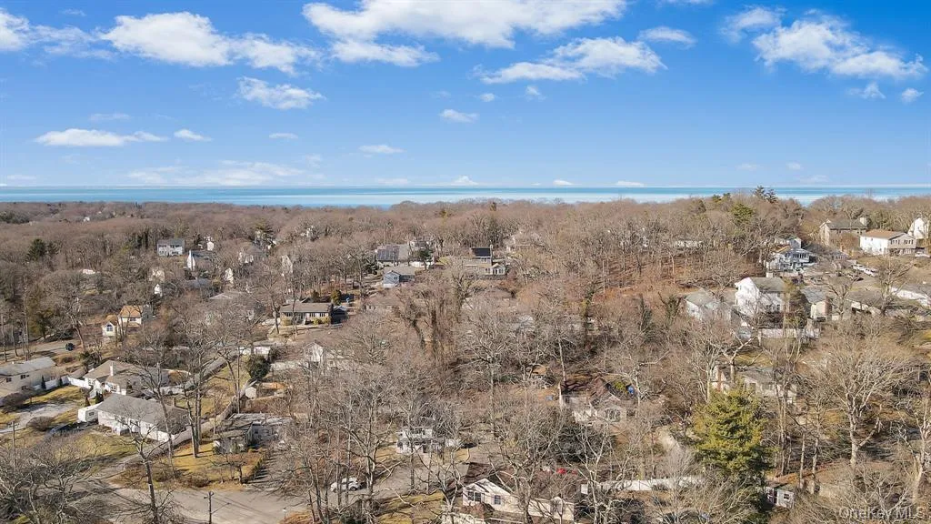 Aerial view of property's location with nearby suburban area and a heavily wooded area Aerial view of property's location with nearby suburban area and a heavily wooded area