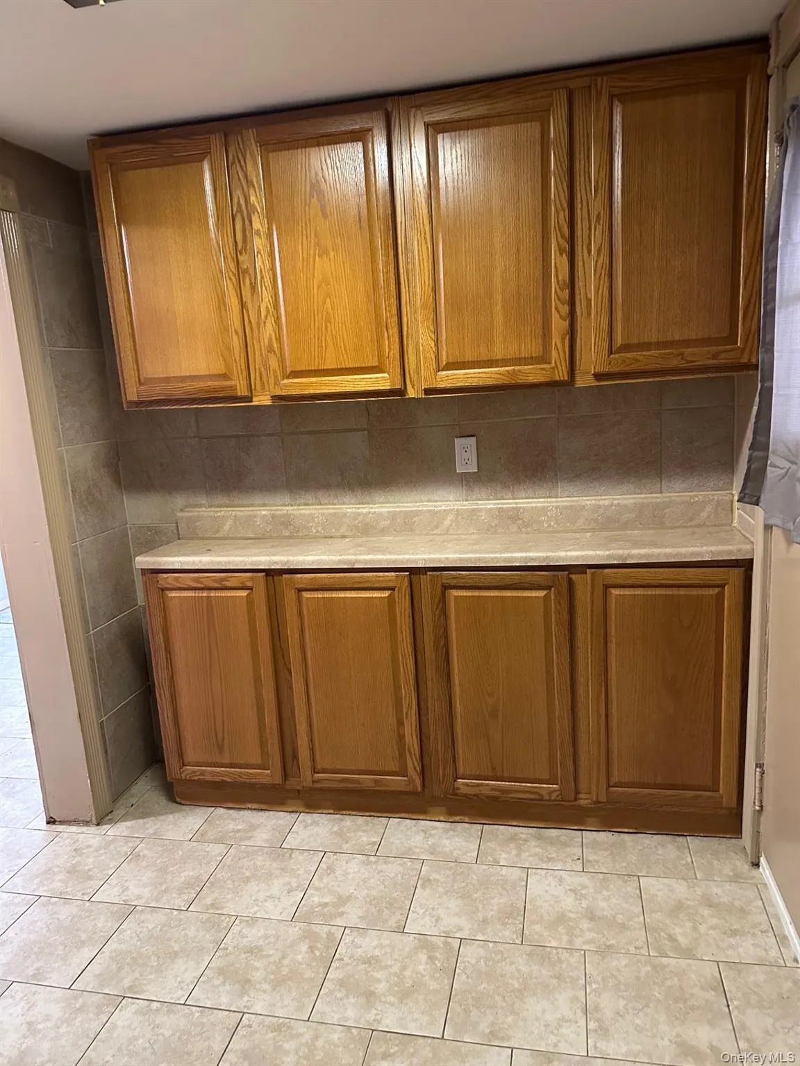 Kitchen featuring brown cabinetry and light countertops Kitchen featuring brown cabinetry and light countertops