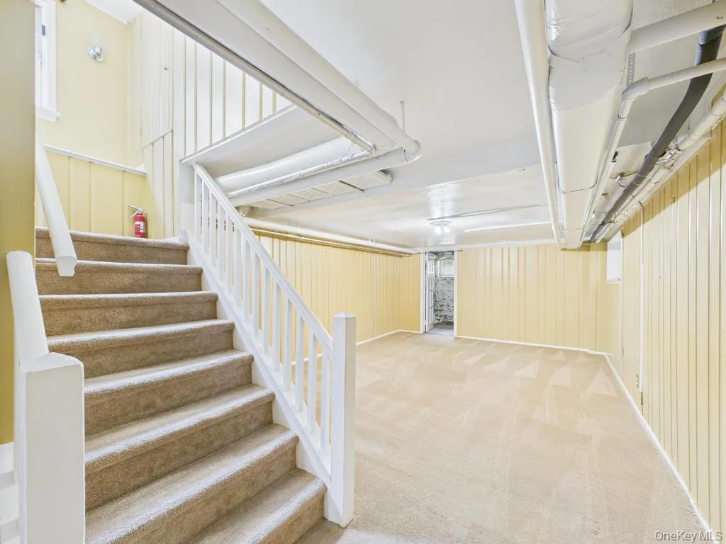 Finished basement featuring carpet flooring and stairs Finished basement featuring carpet flooring and stairs