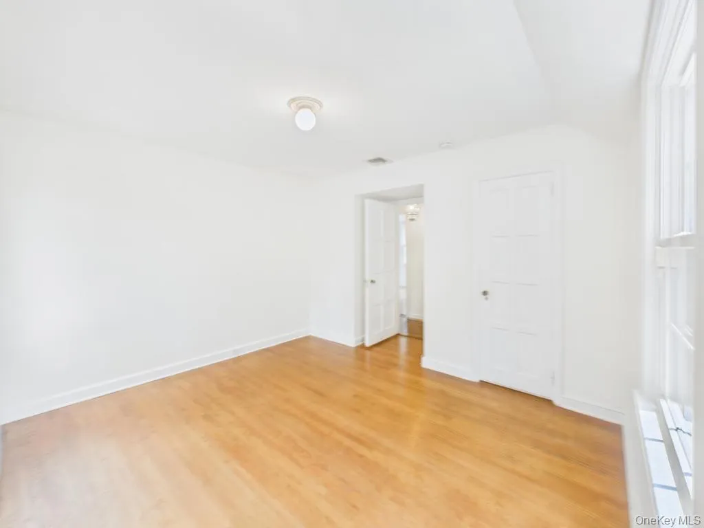 Unfurnished bedroom featuring light wood finished floors and vaulted ceiling Unfurnished bedroom featuring light wood finished floors and vaulted ceiling