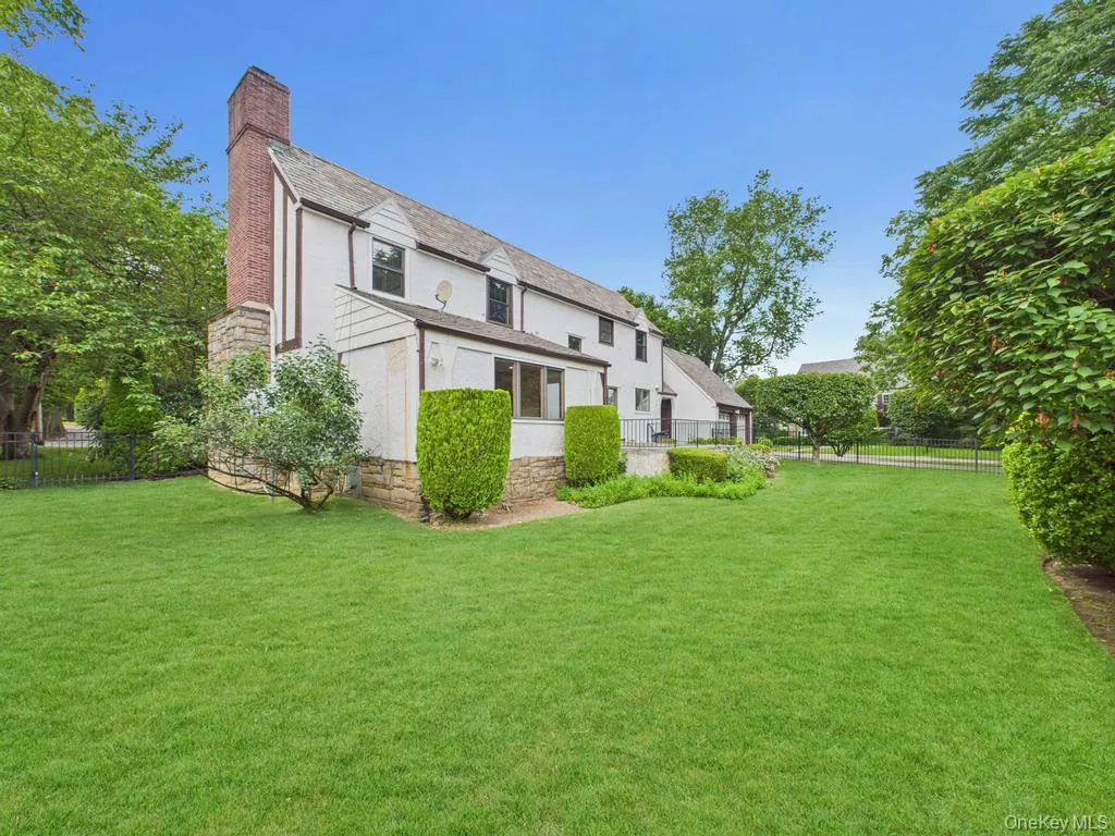 Back of property featuring a chimney, stucco siding, and stone siding Back of property featuring a chimney, stucco siding, and stone siding