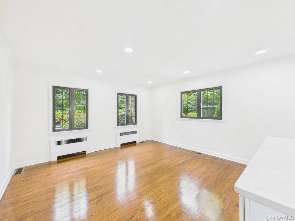 Unfurnished room with radiator, light wood-style floors, recessed lighting, and ornamental molding Unfurnished room with radiator, light wood-style floors, recessed lighting, and ornamental molding