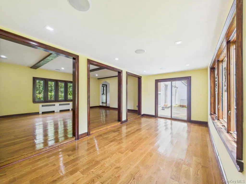 Unfurnished living room featuring radiator and light wood-style flooring Unfurnished living room featuring radiator and light wood-style flooring