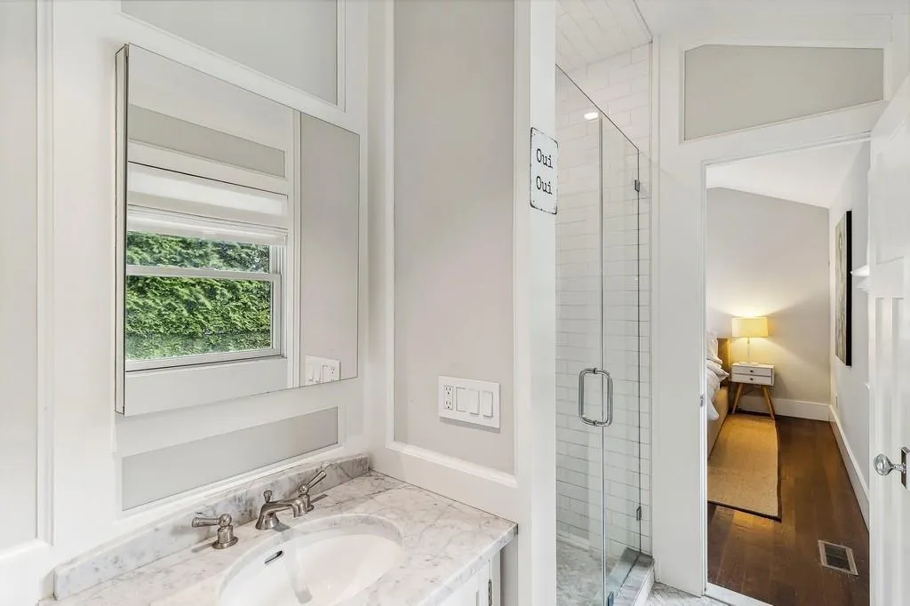 Bathroom featuring a stall shower, vanity, and wood finished floors Bathroom featuring a stall shower, vanity, and wood finished floors