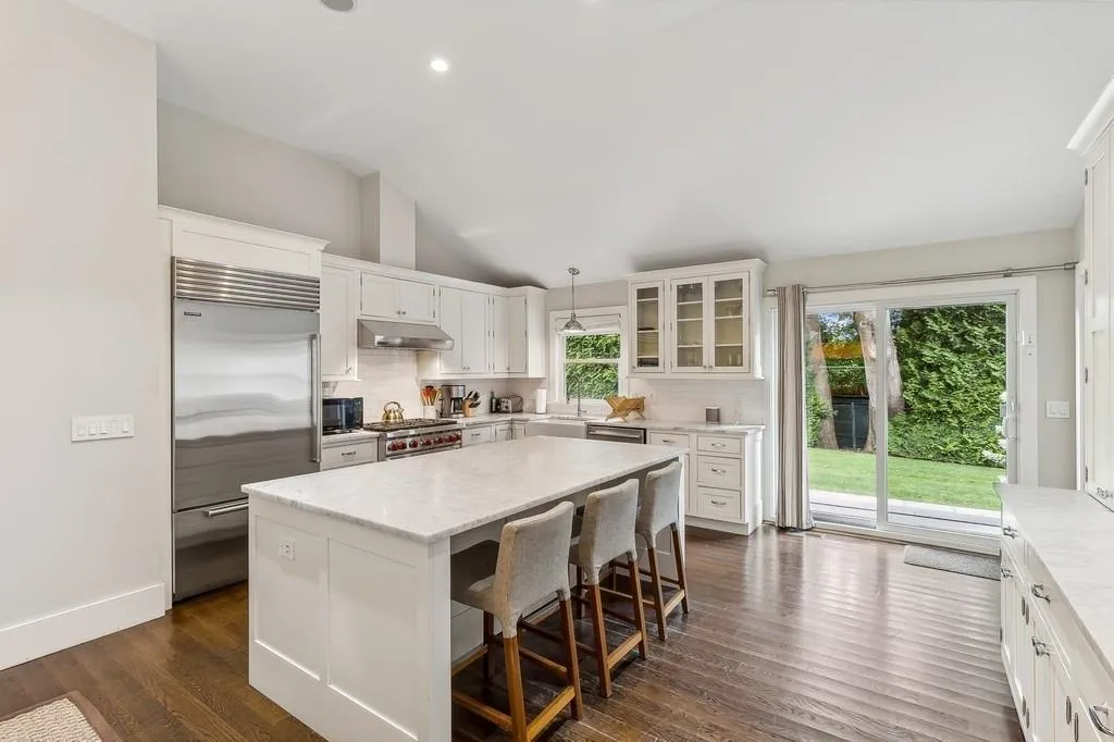 Kitchen with premium appliances, under cabinet range hood, vaulted ceiling, a center island, and backsplash Kitchen with premium appliances, under cabinet range hood, vaulted ceiling, a center island, and backsplash