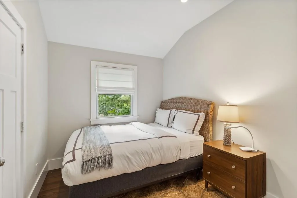 Bedroom with vaulted ceiling and wood finished floors Bedroom with vaulted ceiling and wood finished floors