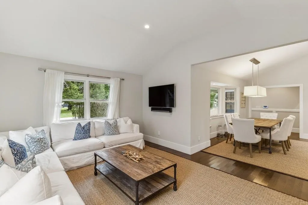 Living room with vaulted ceiling, wood finished floors, and plenty of natural light Living room with vaulted ceiling, wood finished floors, and plenty of natural light