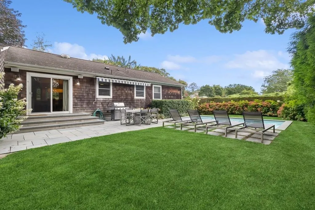 View of grassy yard featuring a patio area View of grassy yard featuring a patio area