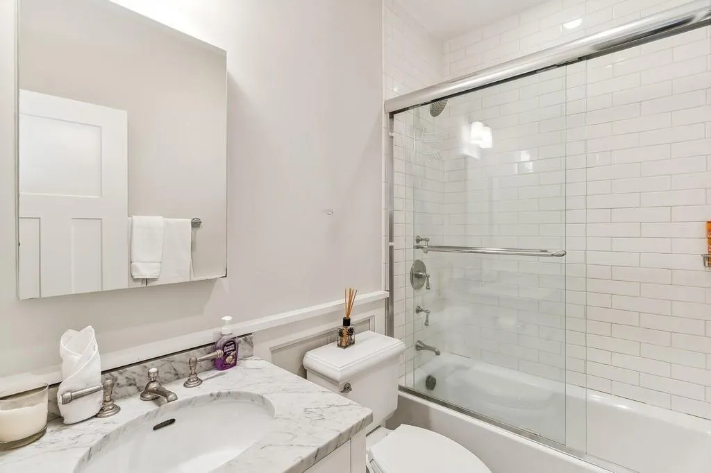 Bathroom featuring vanity and shower / bath combination with glass door Bathroom featuring vanity and shower / bath combination with glass door
