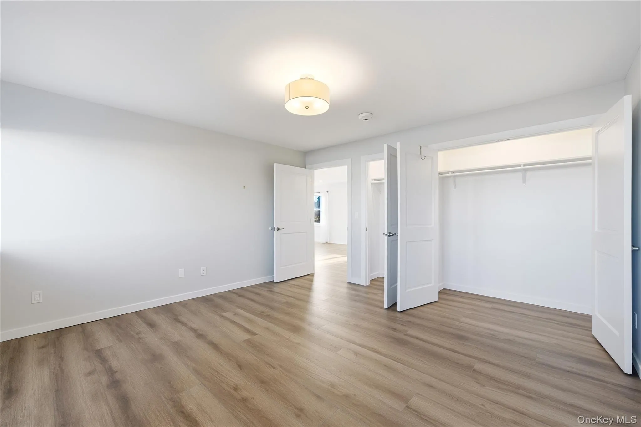 Another view of bedroom featuring light wood-style flooring and a closet Another view of bedroom featuring light wood-style flooring and a closet