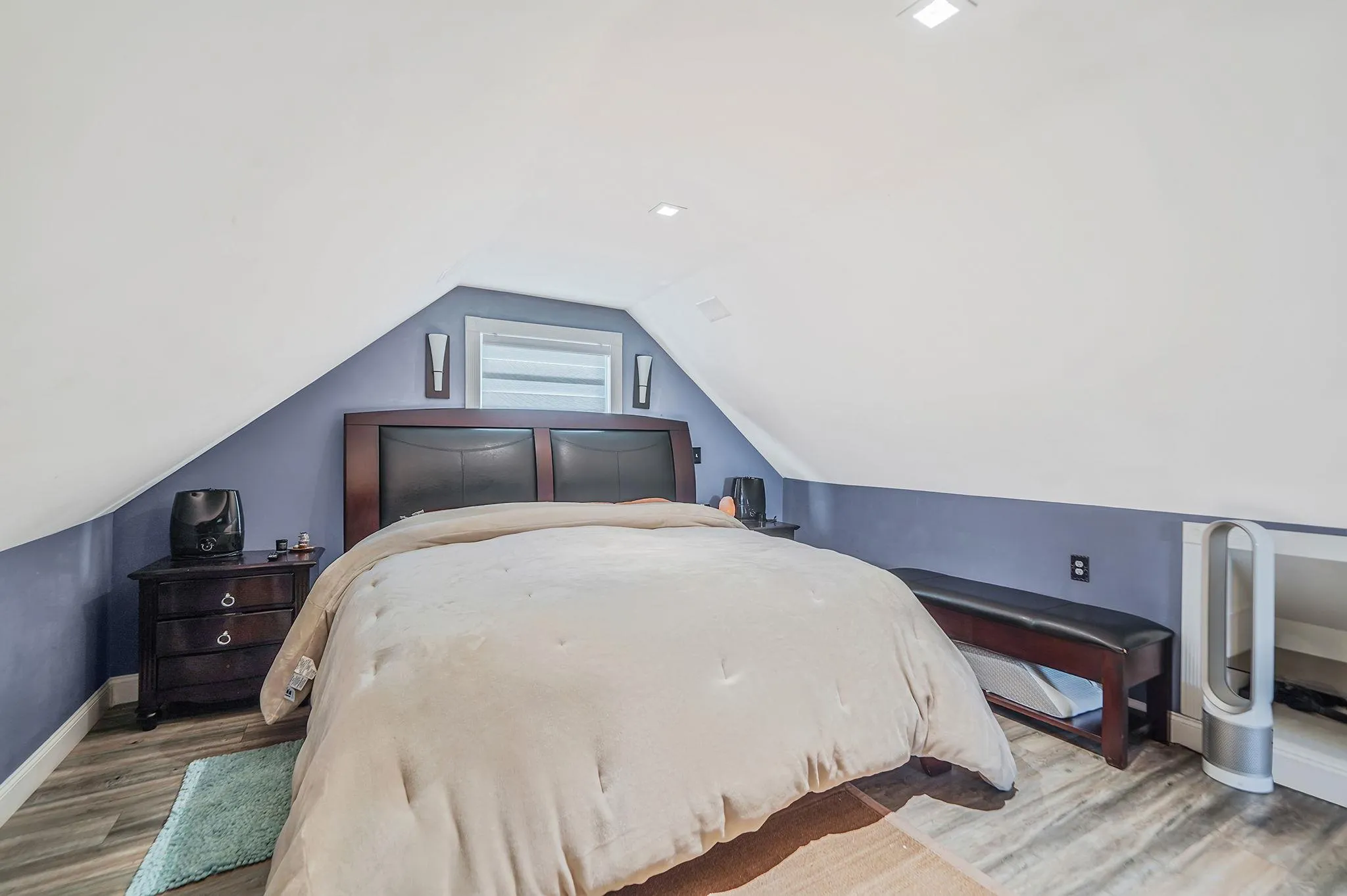 Bedroom featuring wood finished floors and vaulted ceiling Bedroom featuring wood finished floors and vaulted ceiling