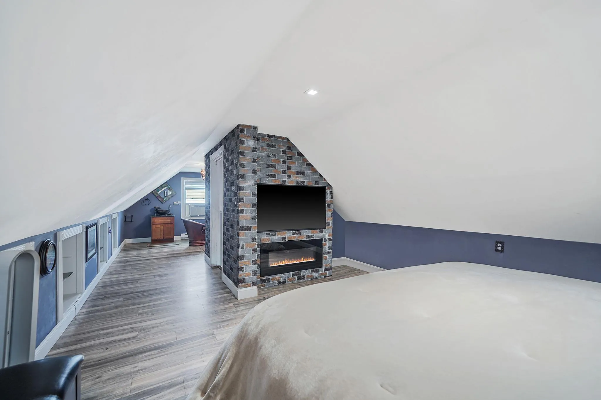 Bedroom featuring wood finished floors and lofted ceiling Bedroom featuring wood finished floors and lofted ceiling