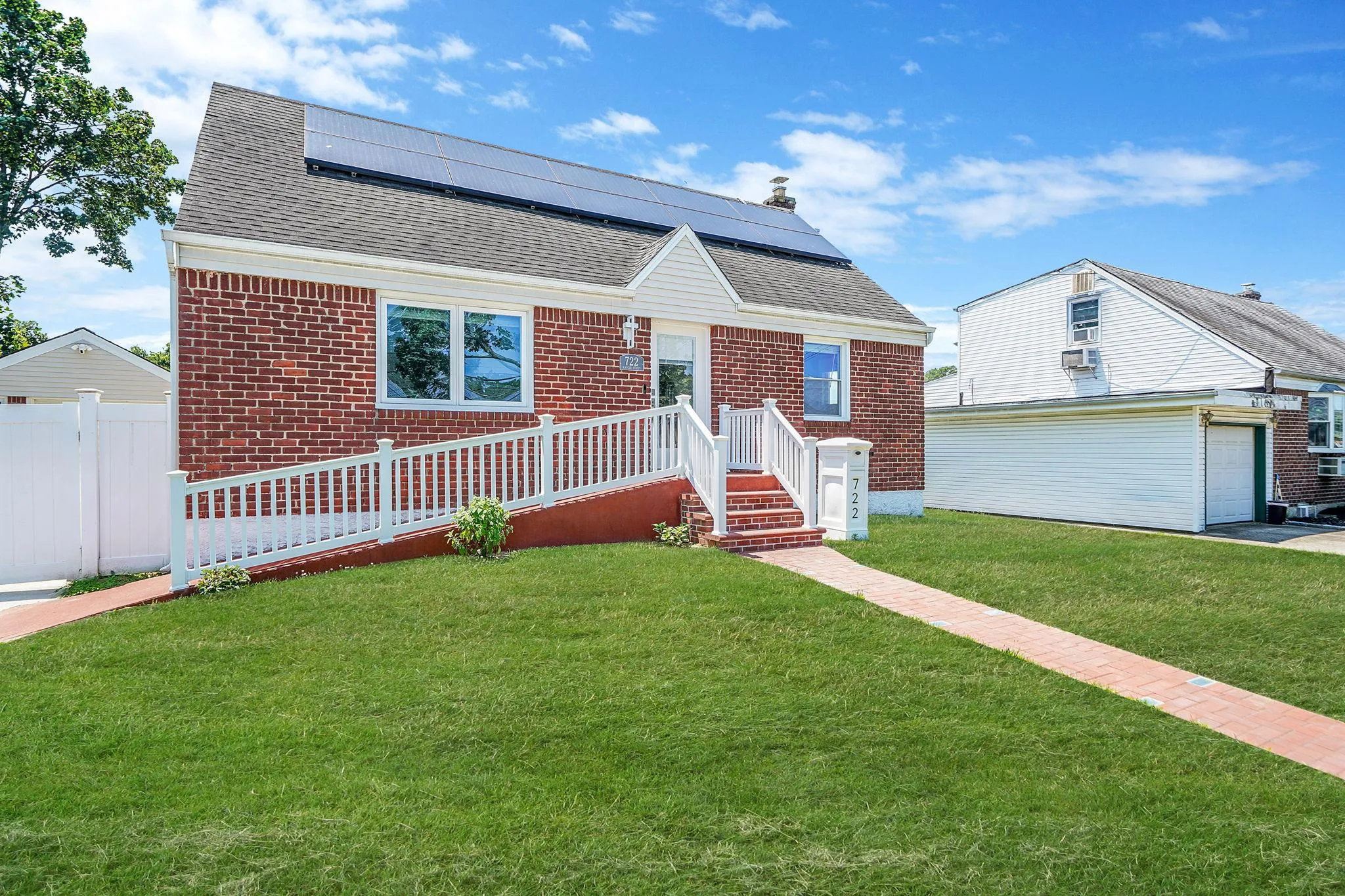 Bungalow-style house featuring brick siding, roof mounted solar panels, a shingled roof, and a garage Bungalow-style house featuring brick siding, roof mounted solar panels, a shingled roof, and a garage