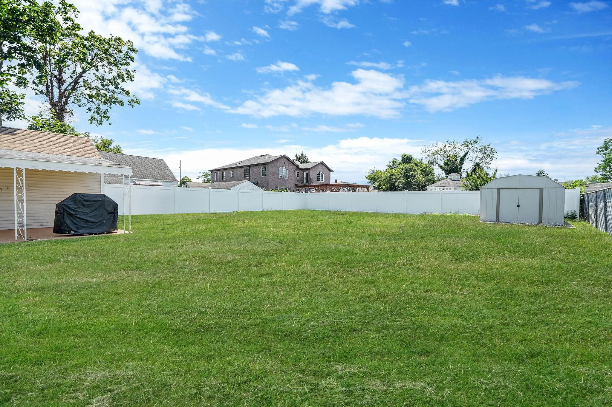 Fenced backyard featuring a storage unit Fenced backyard featuring a storage unit