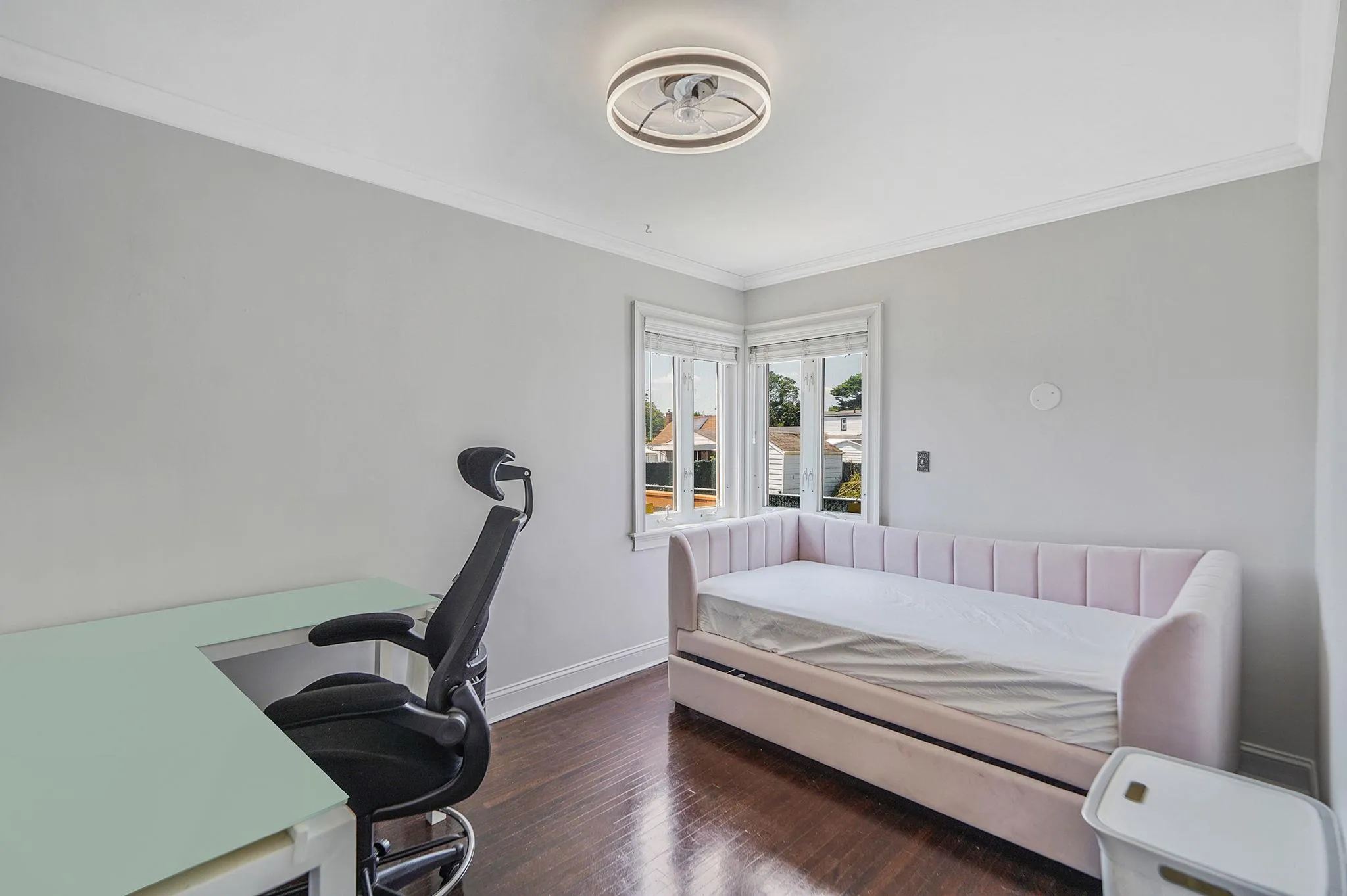 Bedroom with ornamental molding, an office area, and wood finished floors Bedroom with ornamental molding, an office area, and wood finished floors