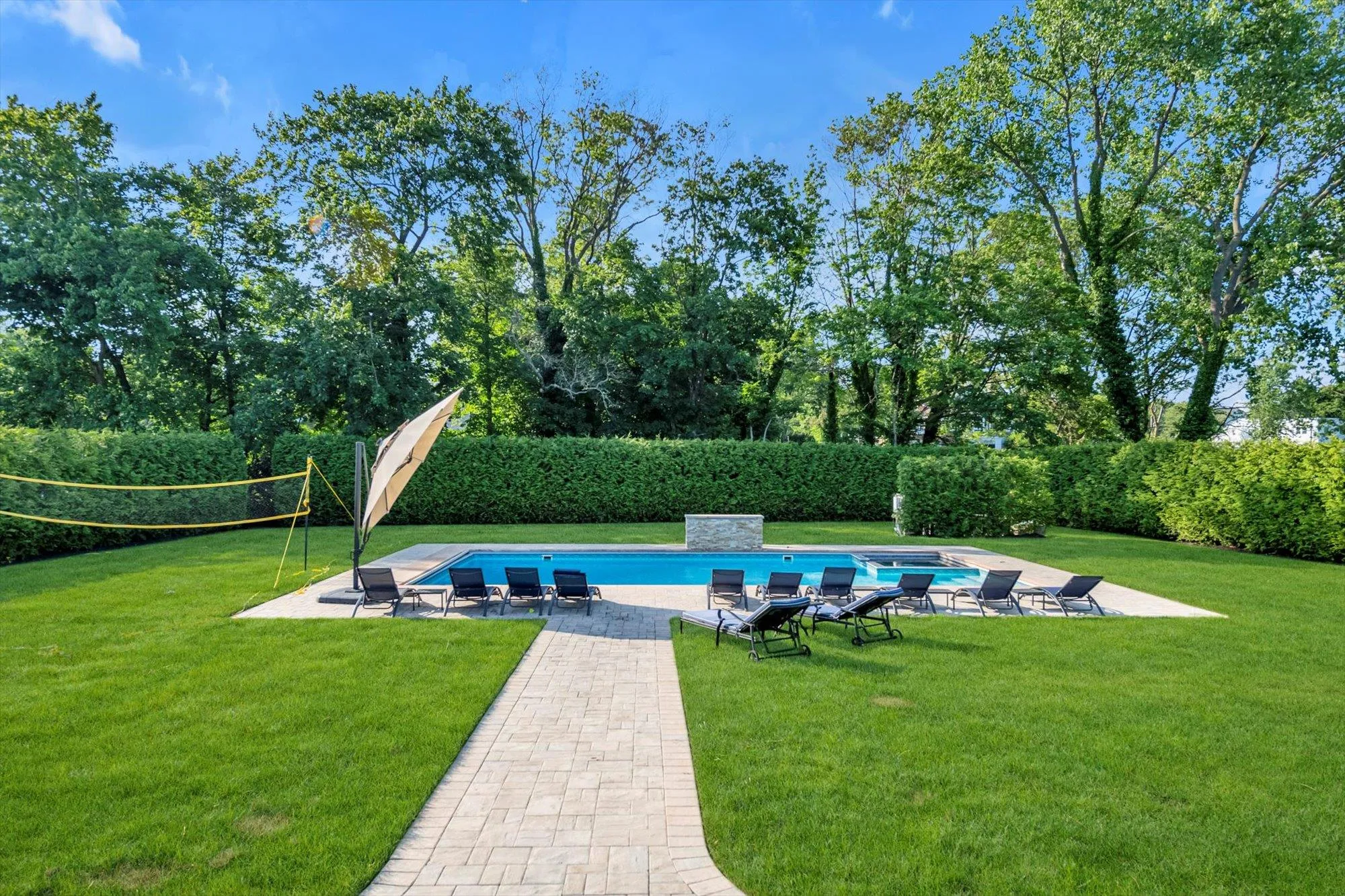 View of swimming pool featuring a patio area, view of wooded area, and a fenced backyard View of swimming pool featuring a patio area, view of wooded area, and a fenced backyard