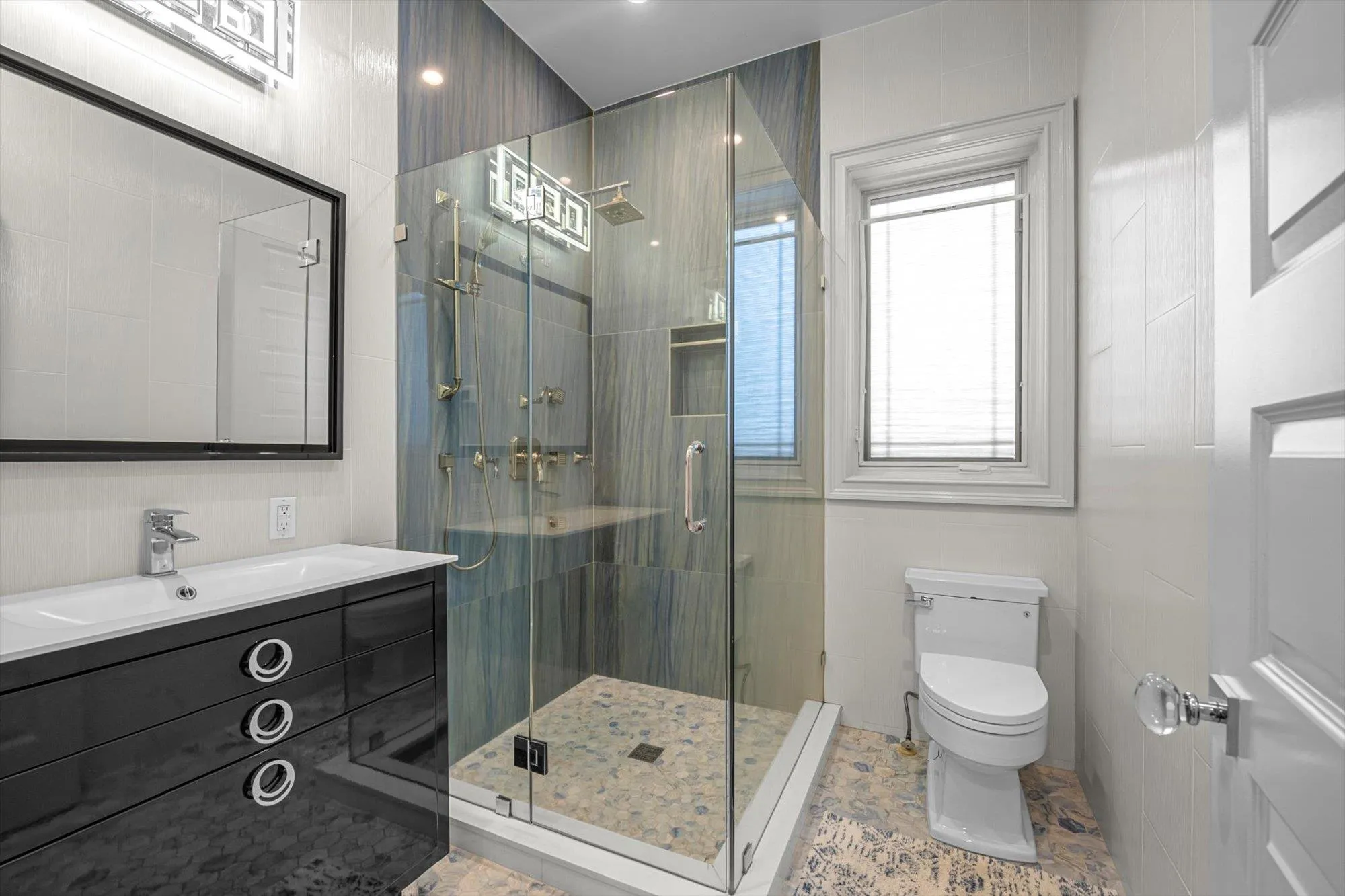 Full bath with vanity, a stall shower, and tile walls Full bath with vanity, a stall shower, and tile walls