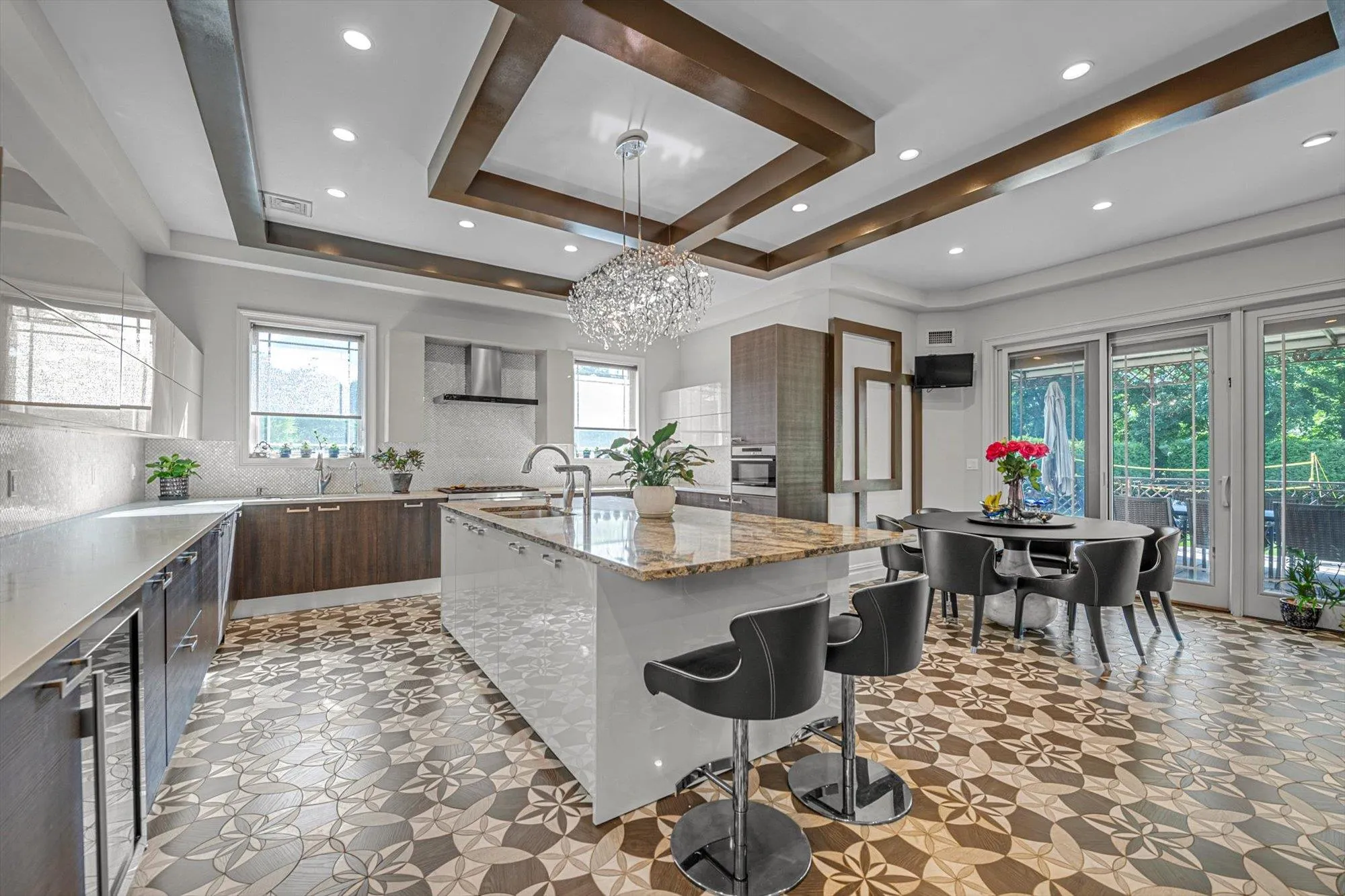 Kitchen featuring modern cabinets, beverage cooler, backsplash, a breakfast bar, and wall chimney exhaust hood Kitchen featuring modern cabinets, beverage cooler, backsplash, a breakfast bar, and wall chimney exhaust hood