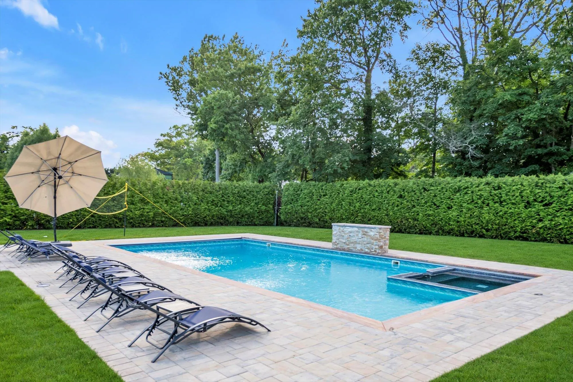View of swimming pool featuring a lawn, a patio area, and a pool with connected hot tub View of swimming pool featuring a lawn, a patio area, and a pool with connected hot tub
