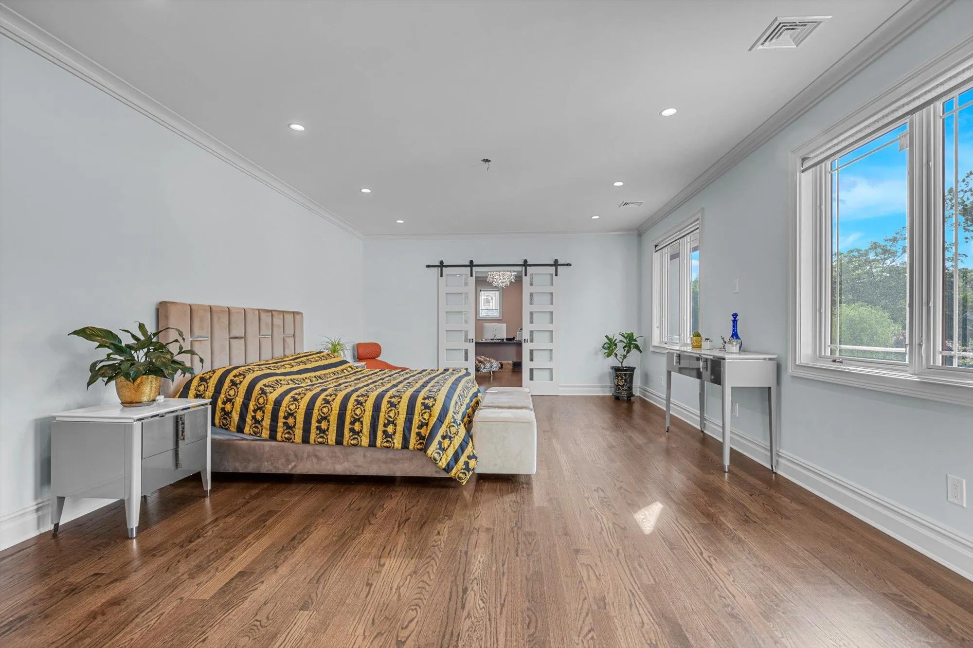 Second Floor Primary Bedroom with Ensuite Spa Bathroom, Office behind barn door, wood finished floors, recessed lighting, and ornamental molding Second Floor Primary Bedroom with Ensuite Spa Bathroom, Office behind barn door, wood finished floors, recessed lighting, and ornamental molding