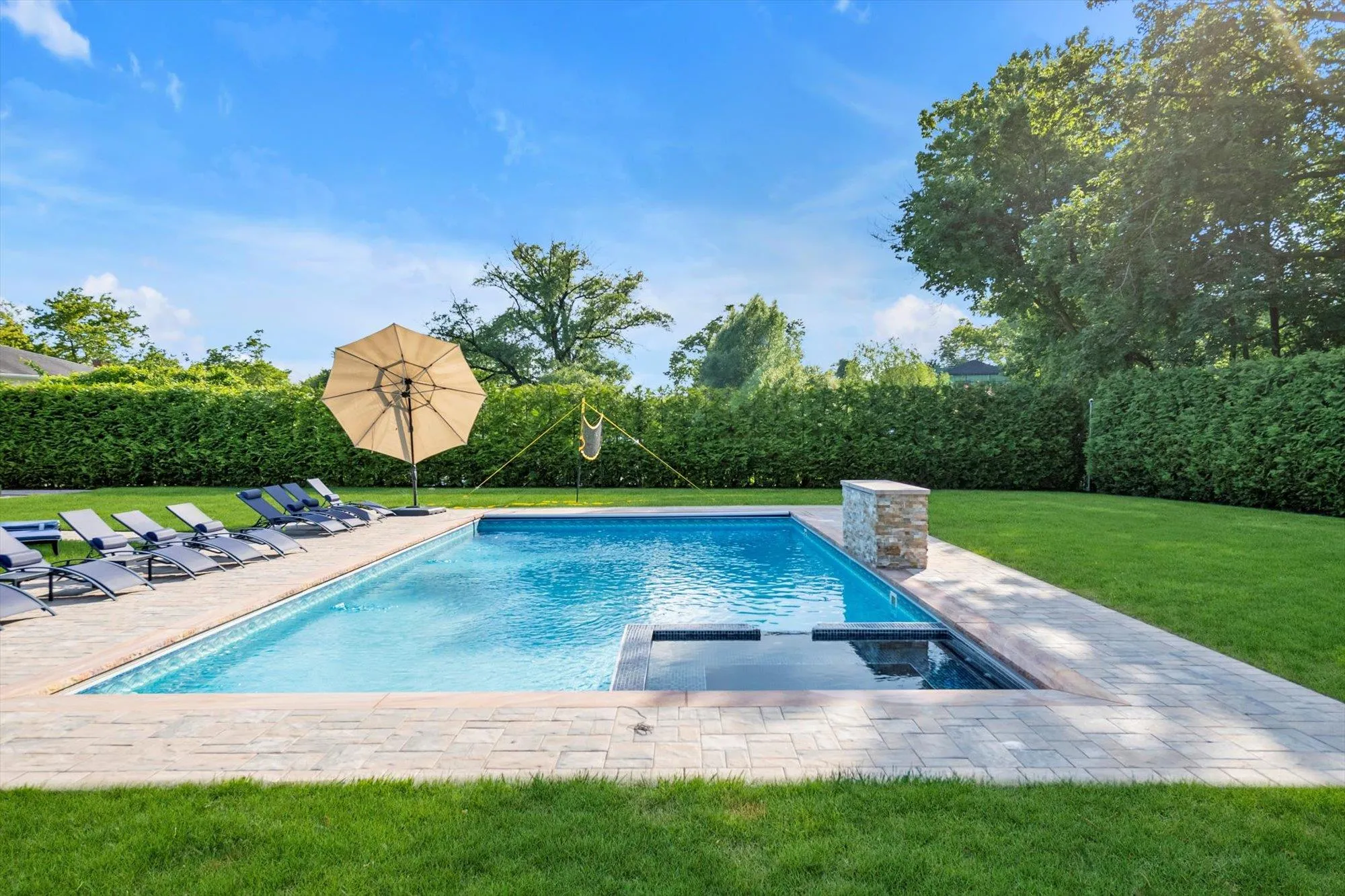 View of pool featuring a lawn, a pool with connected hot tub, and a patio View of pool featuring a lawn, a pool with connected hot tub, and a patio