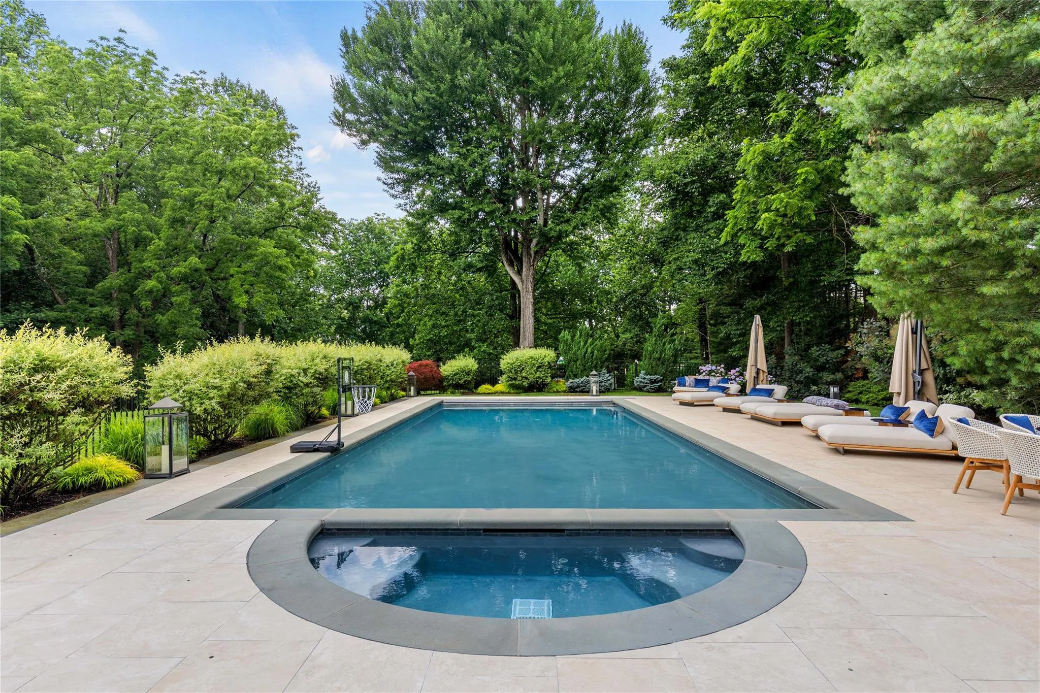 Outdoor pool featuring an in-ground hot tub and a patio area Outdoor pool featuring an in-ground hot tub and a patio area