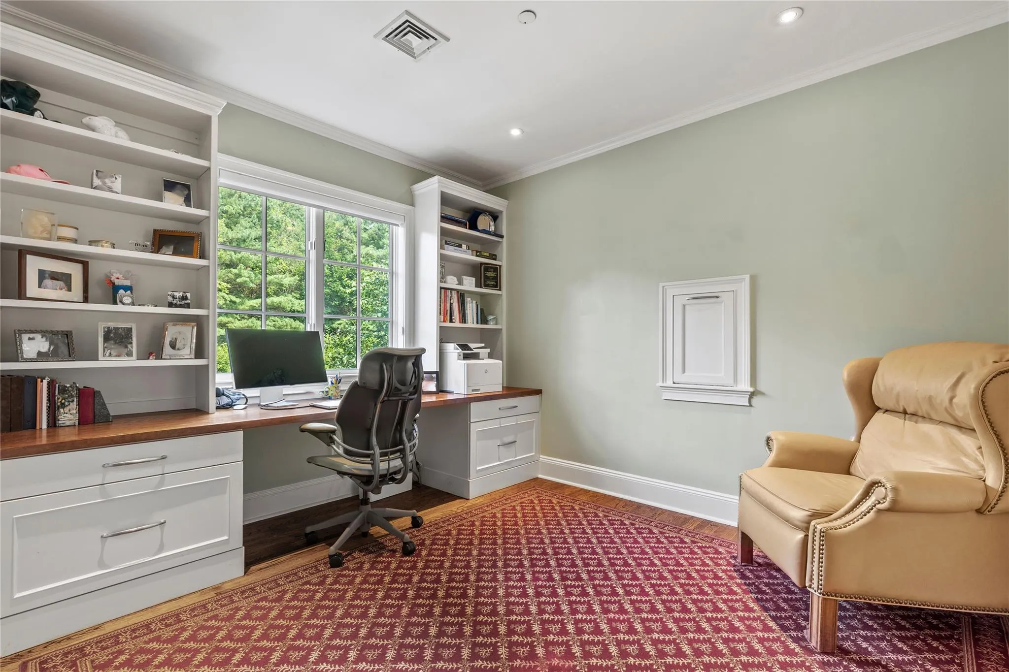 Office space with built in desk, ornamental molding, dark wood-style flooring, and recessed lighting Office space with built in desk, ornamental molding, dark wood-style flooring, and recessed lighting