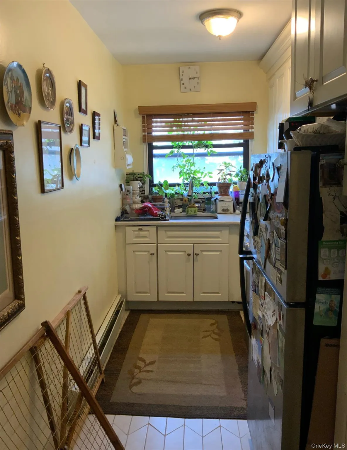 Kitchen featuring freestanding refrigerator, tile patterned flooring, and white cabinets Kitchen featuring freestanding refrigerator, tile patterned flooring, and white cabinets