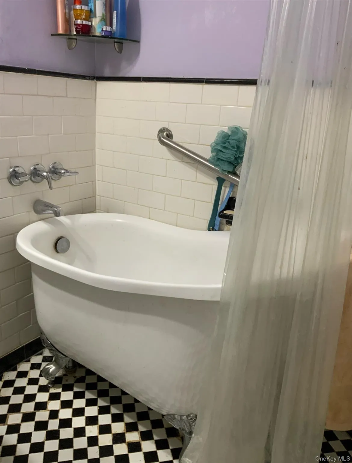 Full bath featuring a soaking tub, tile patterned floors, and tile walls Full bath featuring a soaking tub, tile patterned floors, and tile walls