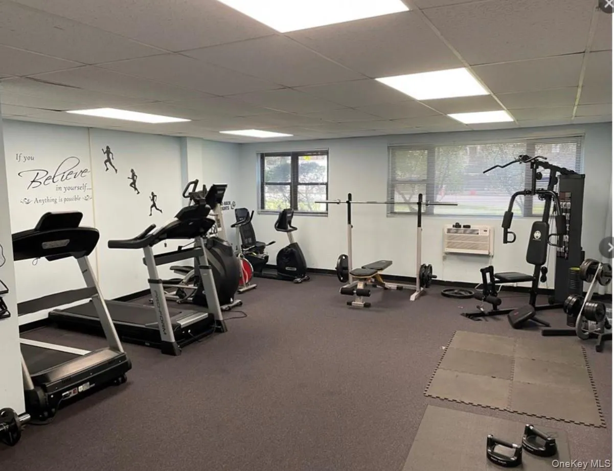 Workout area featuring a paneled ceiling and a wall unit AC Workout area featuring a paneled ceiling and a wall unit AC