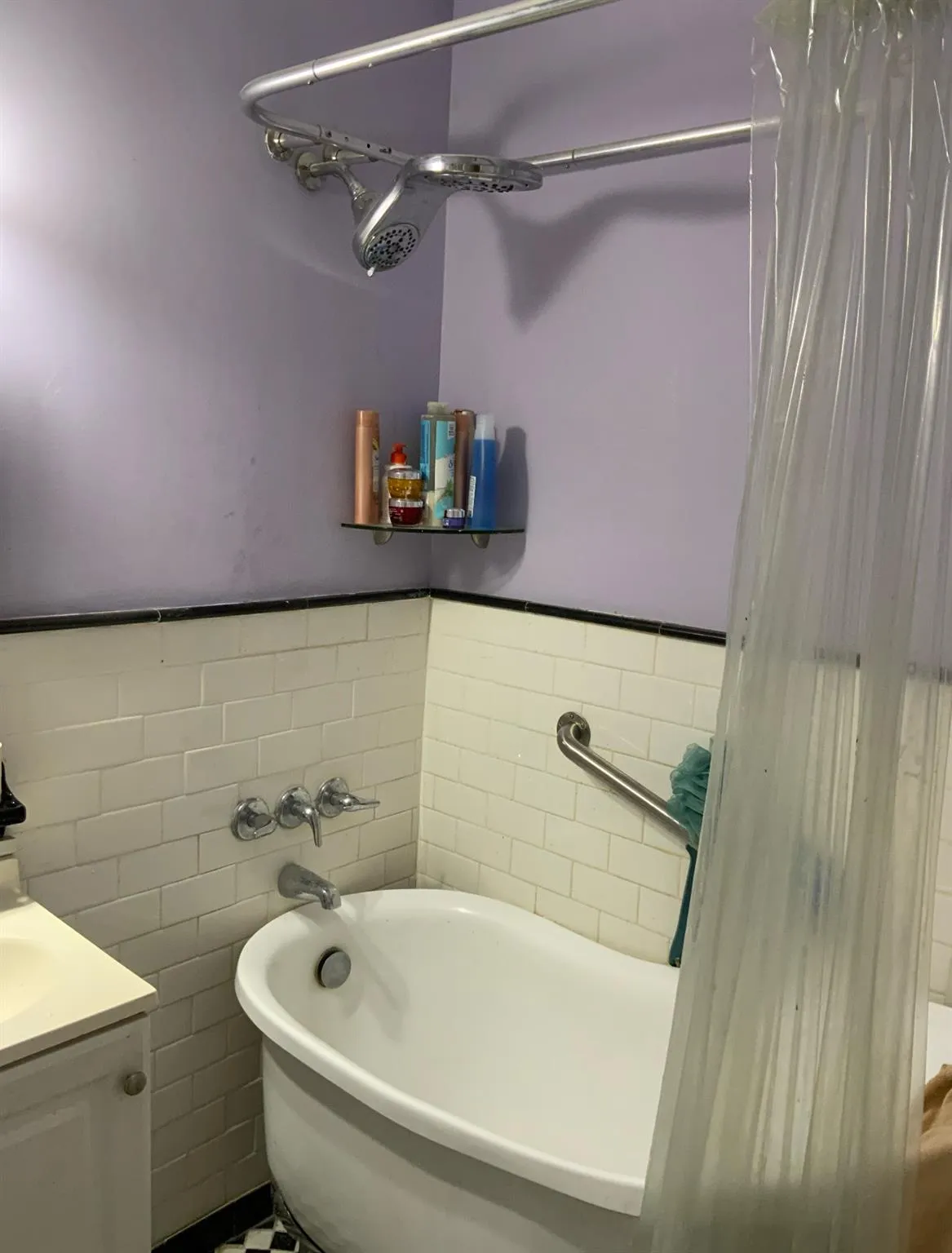 Full bath featuring a tub, tile walls, vanity, and wainscoting Full bath featuring a tub, tile walls, vanity, and wainscoting